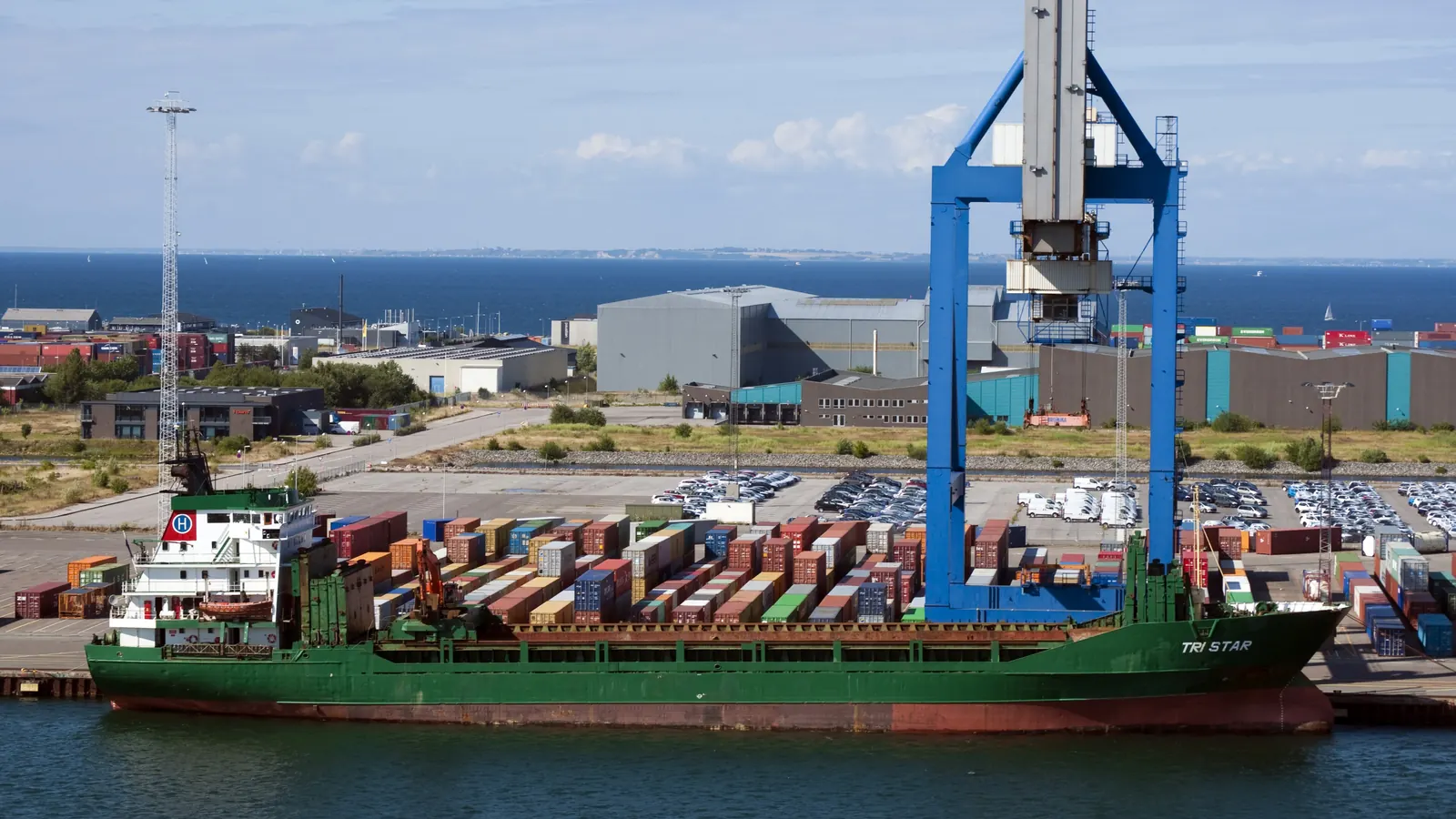 Cargo ship alongside a container terminal where Incoterms rules decide who bears risk and cost