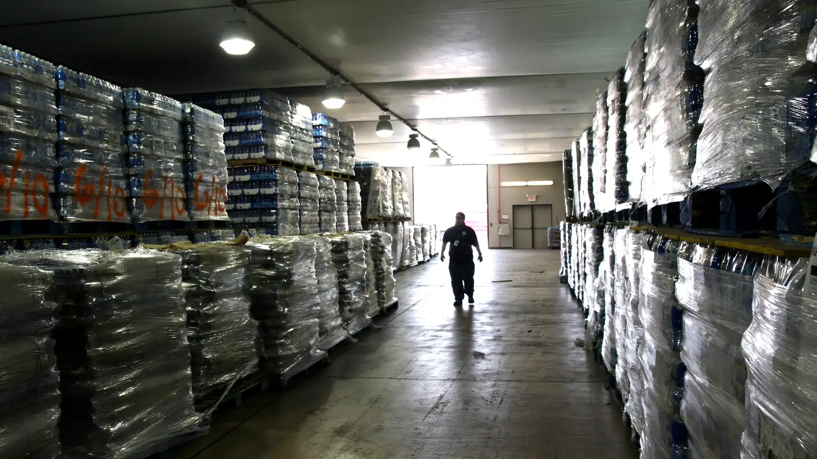 Warehouse aisle with wrapped pallets of stock, the kind of storage a new import business in Dubai needs